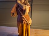 a figurine of a woman holding a bag on a table