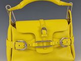 a yellow handbag with a metal handle and two metal handles