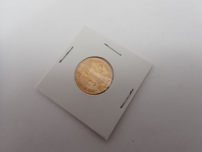 un gros plan d'une pièce de monnaie dans une boîte blanche posée sur une table