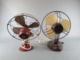 two old fashioned fans sitting side by side on a table
