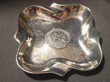 a silver plate with a coin on it on a table