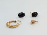 three pairs of gold and black earrings on a white surface