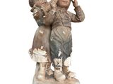 une statue représentant un garçon et une fille sur un socle