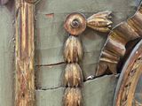 une horloge en or ornée d'un oiseau, posée à côté d'un miroir