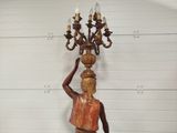 a statue of a man holding a chandelier on his head