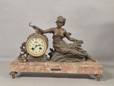 a statue of a woman holding a clock on top of a table