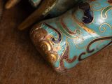 a blue and gold vase sitting on a table next to a pair of scissors