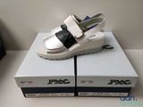 une paire de sandales blanches et noires posées sur des cartons, sur une table