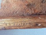 a close up of a piece of wood with writing on it