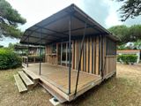 a small wooden structure with a roof on the grass