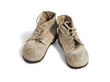 une vieille paire de chaussures posée sur une surface blanche, avec un fond blanc
