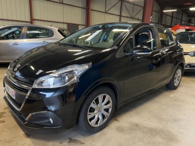 une voiture noire garée dans un garage, avec d'autres voitures en arrière-plan