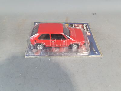 a red toy car that is in a clear box