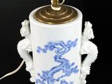 a blue and white vase with a light on it
