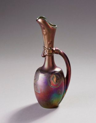 une photo représentant un vase en verre coloré posé sur une table