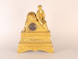 a gold clock sitting on top of a table