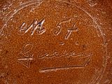 an image of a close up of a brown vase with writing on it
