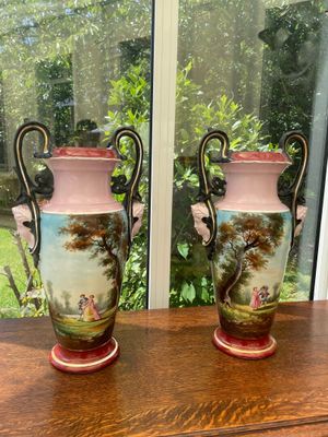 two vases sitting on a table in front of a window