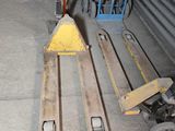 two forklifts and a pallet in a warehouse