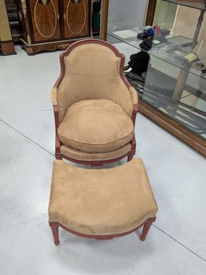 a chair and ottoman in a room with a glass case