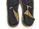 une paire de pantoufles noires et dorées sur fond blanc