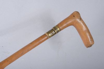 a wooden stick with a metal handle on a white surface