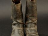 pair of old worn leather boots on a black background