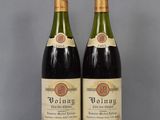 two bottles of wine sitting on top of a table next to each other