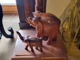 a statue of an elephant and a baby elephant on a wooden stand
