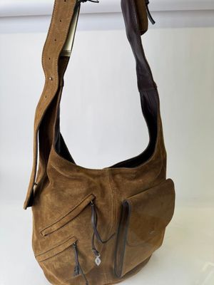 brown leather purse with zippers hanging from a hook on a wall