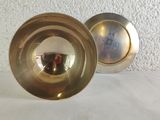 two metal bowls sitting next to each other on a table