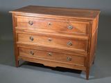 une petite commode en bois sur fond gris