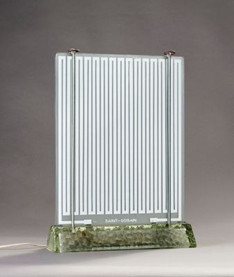 une image représentant une lampe de table avec un pied en verre et une structure métallique