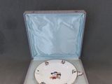 une assiette blanche dans un étui bleu, avec une cuillère et une fourchette