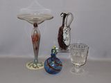 three glass vases on a table next to a glass candle holder