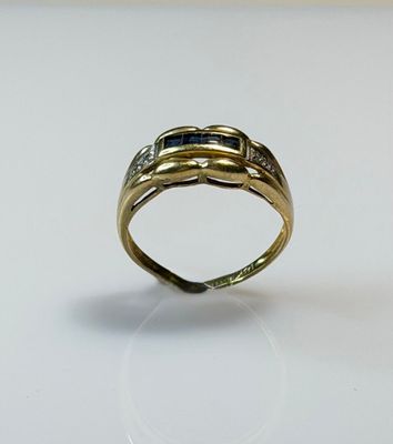 an image of a gold ring with a blue stone