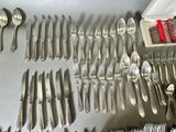 many forks and spoons laid out on a table