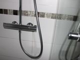 a shower with a glass door and a shower head