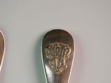 two spoons that are sitting next to each other on a table