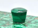 a green glass container sitting on top of a table