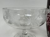 a glass bowl and a bottle sitting on a table