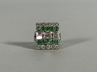 a close up of a green and white diamond ring