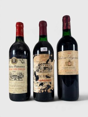 trois bouteilles de vin sont alignées sur une surface blanche