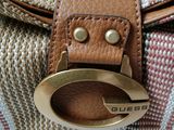 the purse is sitting on a white surface with a brown handle