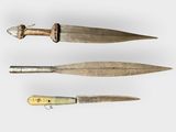 two old knives are sitting next to each other on a white surface