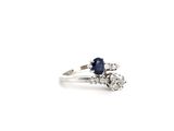 a close up of a diamond and sapphire ring on a white background