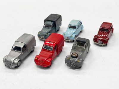 plusieurs petites voitures sont alignées sur une surface blanche