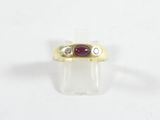 gros plan d'une bague en or avec une pierre en rubis
