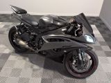 a black motorcycle that is parked on a checkered floor