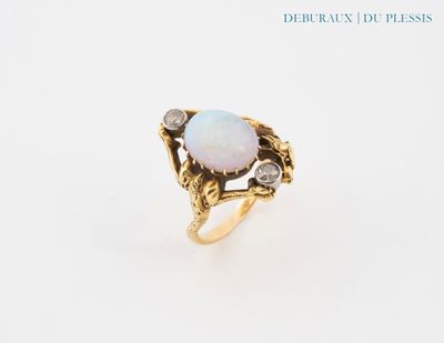 un gros plan d'une bague sertie d'un oplite et de diamants